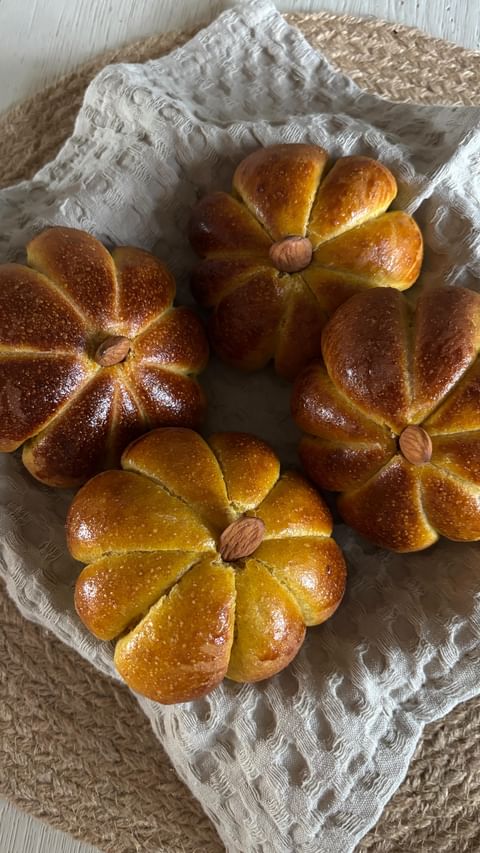 Opskrift på græskarboller 🎃🍁
 
Bløde, lækre græskarboller med græskarmos, krydderier og fuldkornsmel. Disse er et hit hos både store og små!
 
Ingredienser:
200 gram græskarpuré (bag eller kog hokkaidogræskar til det er mørt)
50 gram smør
3 dl. Mælk
20 gram gær
1 spsk sukker eller honning
1 tsk. Salt
1 tsk. Kanel
1 tsk. Kardemomme
1 tsk gurkemeje (for ekstra farve)
450 gram hvedemel
200 gram fuldkornshvedemel
 
Derudover: Kødsnor og mandler eller kerner til “græskarstilke”
 
Sådan gør du:
Kog eller bag græskar til de er helt møre, tilsæt smør og mos det helt blødt.
 
Kom mælk i en skål og rør gæren i. Tilsæt græskarpure, salt, sukker og krydderier.
Rør sammen med begge slags mel, tilsæt lidt af gangen. Ælt dejen godt sammen eller kør den i røremaskine til den ikke klistrer længere og slipper kanterne - ca. 10 min.
Dæk skålen til og stil dejen til hævning et lunt sted i ca. 1,5 time.
 
Tag dejen ud og del den i ca. 14 stykker som trilles til boller.
 
Sæt bollerne på plader med bagepapir og og lad dem efterhæve tildækket i ca. 45 min.
 
Klip kødsnore ud i a’ ca. 10 cm - 6 stk pr. bolle og bind dem sammen hver især, til de danner et græskarmønster.
 
Pensl med æg og tryk en græskar “stilk” ned i midten af hver bolle.
 
Bages ved 200 grader i ca. 15 minutter